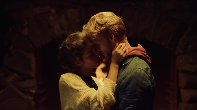 Photo a man and woman are kissing in a dark room.