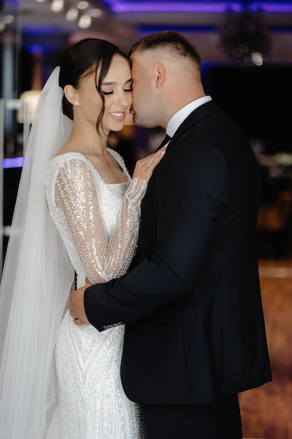 a man and a woman are kissing in front of a window