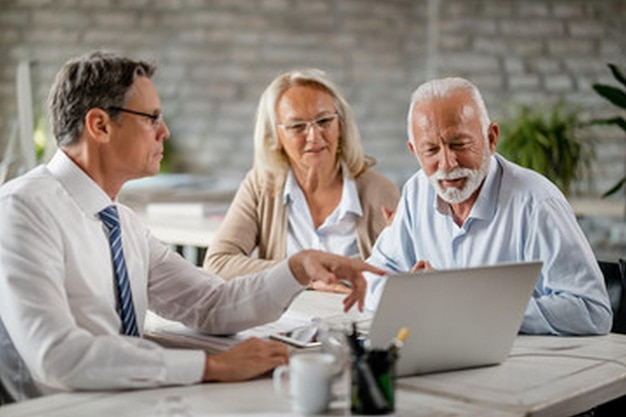 a man and a woman are looking at a laptop