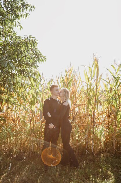 Man and woman are near the corn. Love and happiness concept. Couple in field. Autumn time.