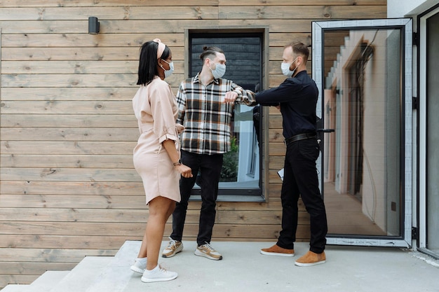 a man and woman are outside a house with a mask on his face