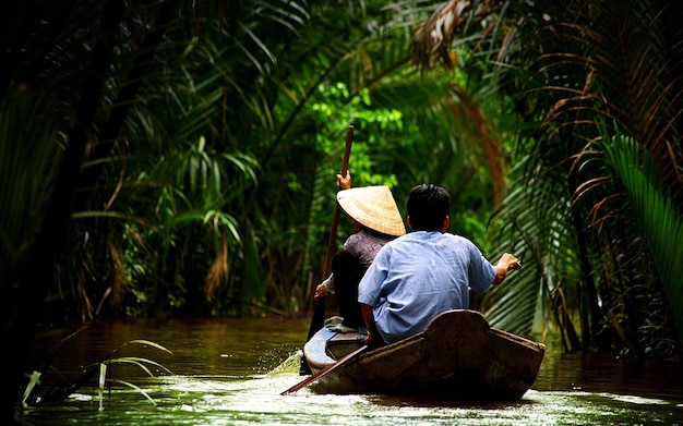 a man and a woman are riding a canoe in the water