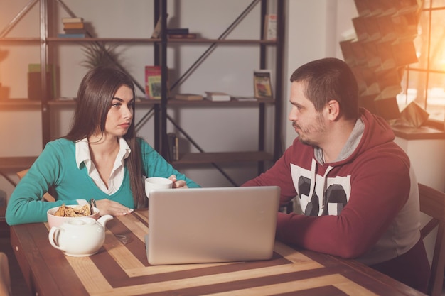 Man and woman are sitting at the table and discussing something