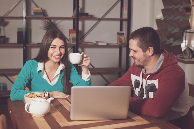 Man and woman are sitting at the table and laughing