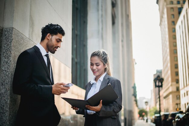 a man and woman are standing in front of a building with a sign that says business