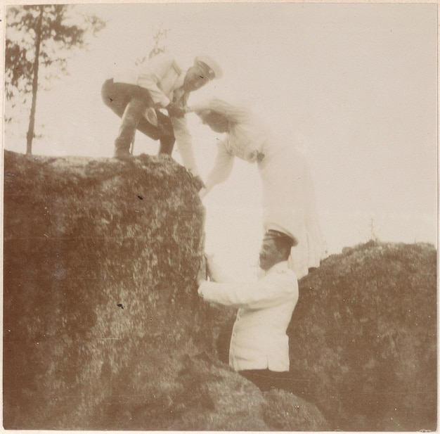 a man and woman are standing on a rock one of which has a white dress on it