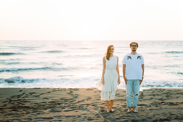 남자와 여자는 바다의 모래 위에 서있다
