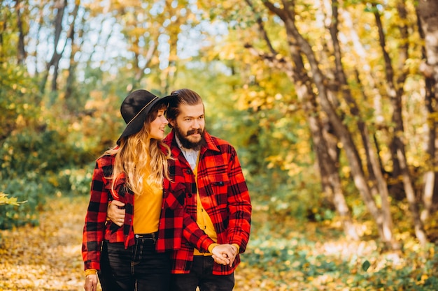 Man and woman are walking in the autumn forest