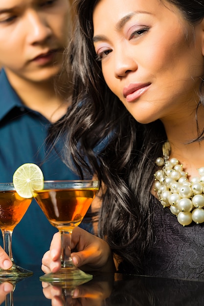 Photo man and woman in asia at bar with cocktails