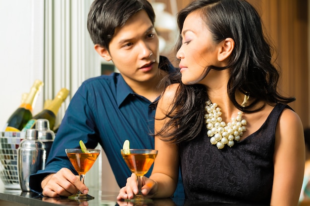 Uomo e donna in asia al bar con cocktail