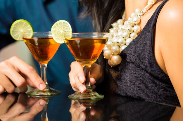 Man and woman at bar with cocktails