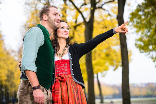 Man and woman in Bavarian Tracht, girl pointing 