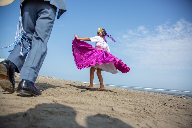 Photo a man and a woman on the beach with a purple dress on