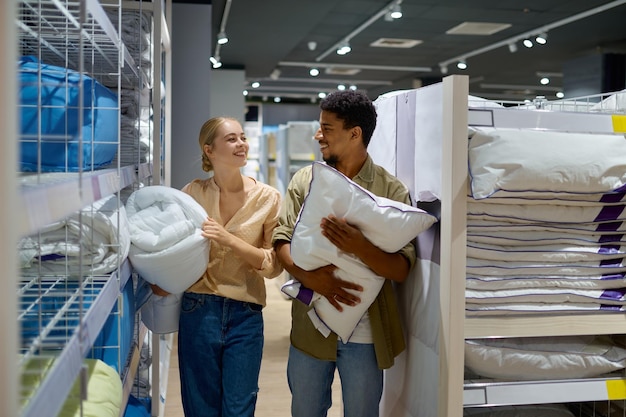 Man and woman buying bedding in supermarket