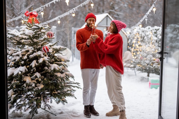 Man and woman celebrate new years holidays with sparklers outdoors