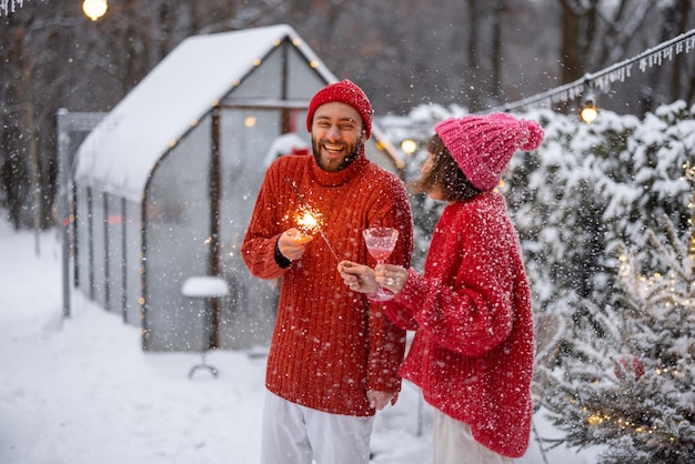 Man and woman celebrate new years holidays with sparklers outdoors