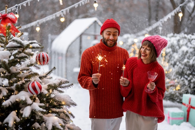 Man and woman celebrate new years holidays with sparklers outdoors