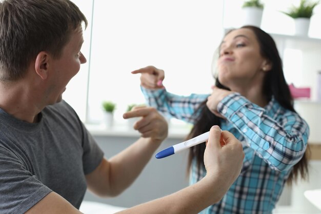 Man and woman communicating with pregnancy test in hands