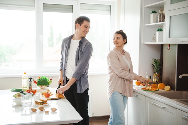 Man and woman cooking organic sandwich in kitchen room they feeling happy and smile healthy vegetari...