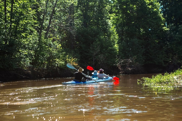 Man and woman couple in family kayak trip rowing boat on the river a water hike a summer adventure Ecofriendly and extreme tourism active and healthy lifestyle