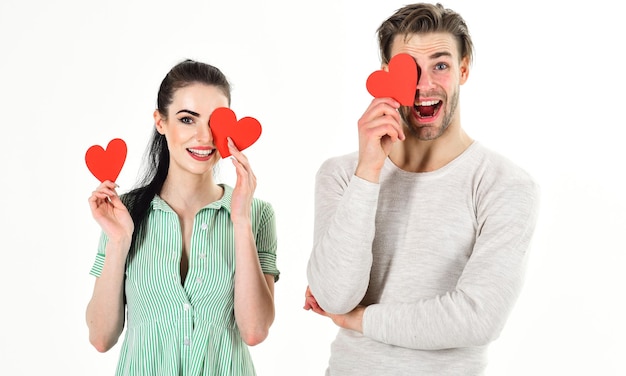 Man and woman couple in love hold red heart valentines cards on white background Romantic couple in love Romantic feelings concept Valentines day and love Handsome man and pretty girl in love