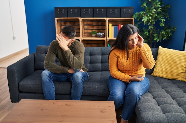 Man and woman couple with problems sitting on sofa at home