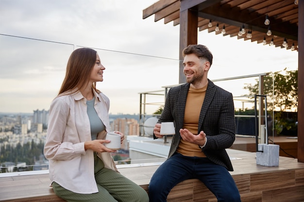 Photo man and woman coworkers having nice conversation at office balcony