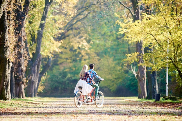 Man and woman cycling together tandem double bike