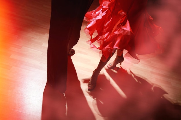 Man and woman dancing salsa on dark