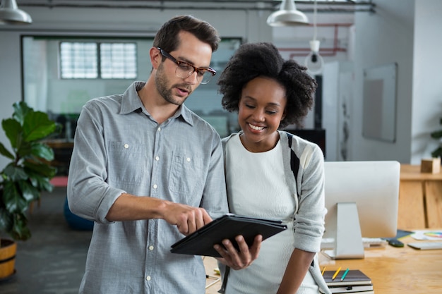 Man and woman discussing over digital laptop