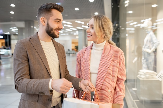 A man and a woman discussing what they bought in the mall