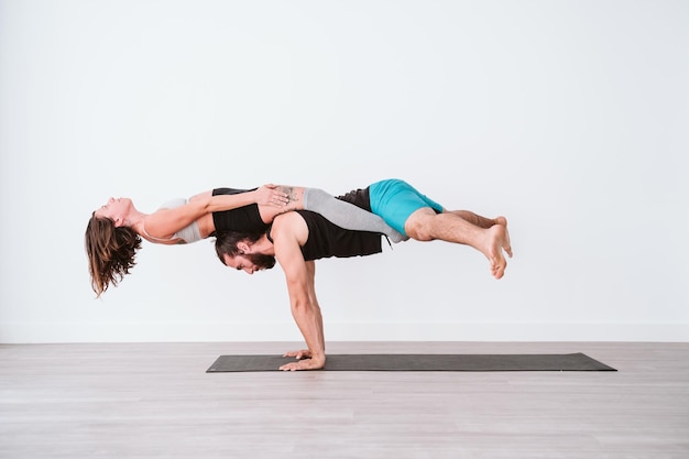 man and woman doing yoga on floor