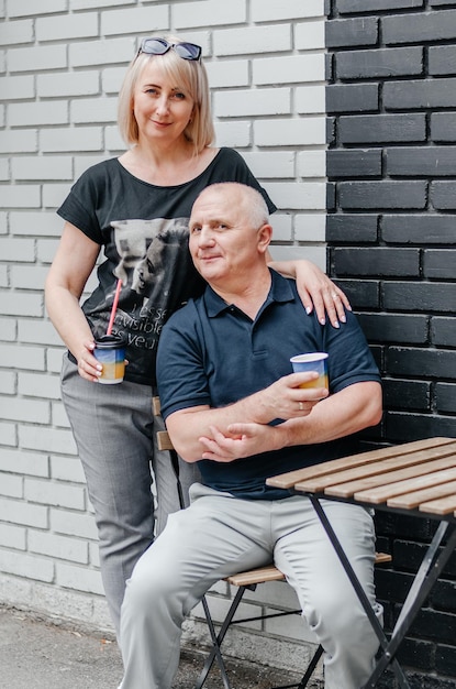 мужчина и женщина пьют кофе возле черно-белой стены