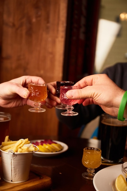 男性と女性はパブで異なる酒を飲みます友人はバーでアルコール飲料を飲んでいます