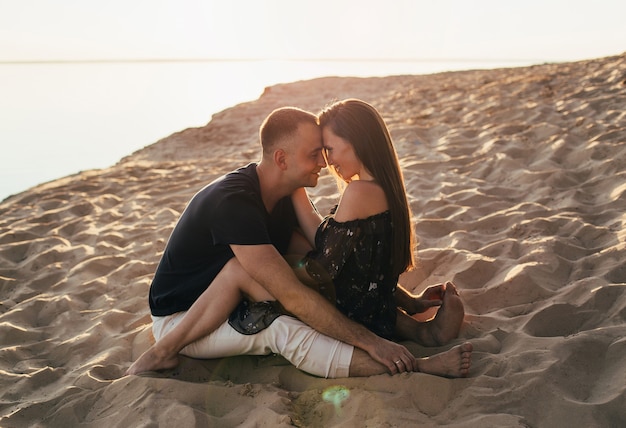 Photo man and woman in each other's arms on the beach in summer