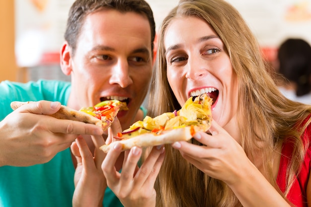 男と女のピザを食べる