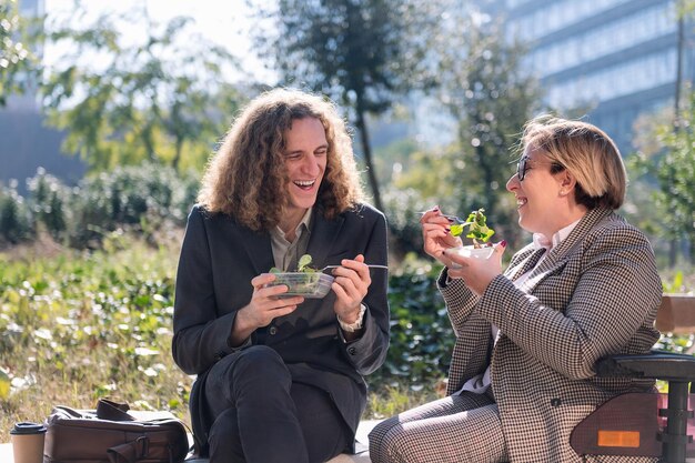 Photo man and woman eating a salad on a break from work