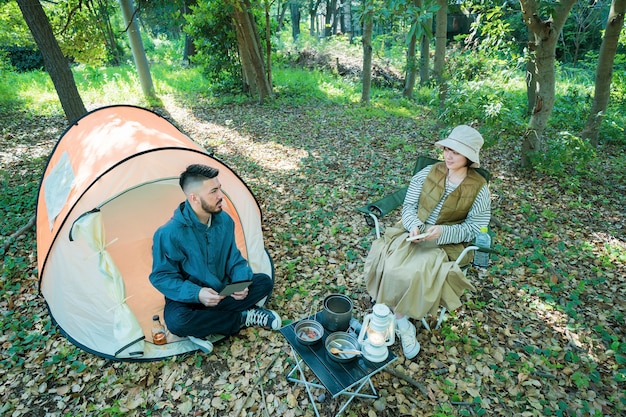 Man and woman enjoying camping in the forest