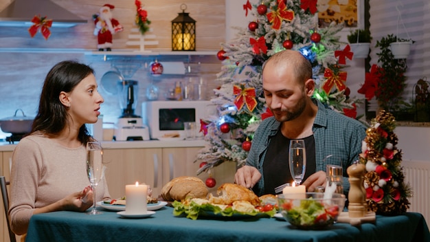 クリスマスにお祝いの夕食を楽しんでいる男性と女性