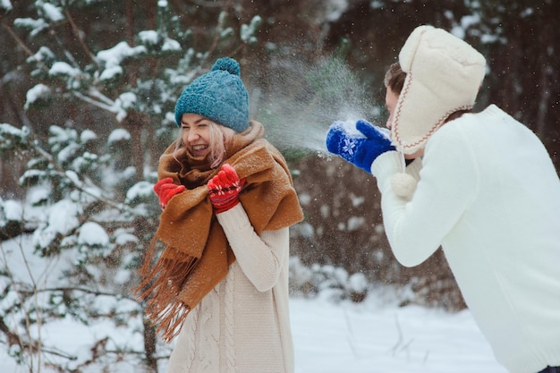 冬に雪の中で楽しんでいる男と女