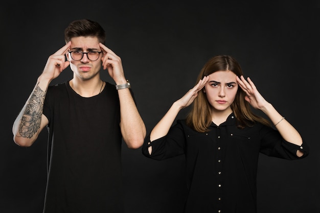 Man and woman feeling stressed and angry at each other,
frustrated couple hands on head, not talking after dispute,
teenagers quarrel, family crisis and relationships problems