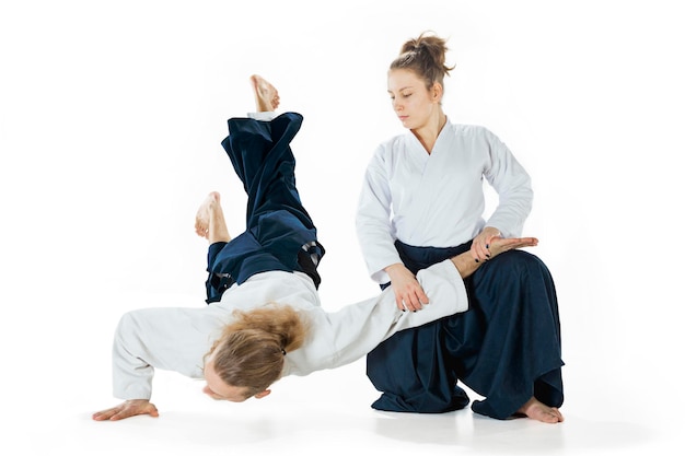 Man and woman fighting and training aikido on white