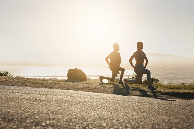 Man woman or fitness stretching at sunset for exercise training or workout for heart health cardio or muscle growth Runners sports team or athletes in wellness warm up on remote mountain sunrise