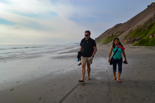 Man and woman friends walking along the seashore