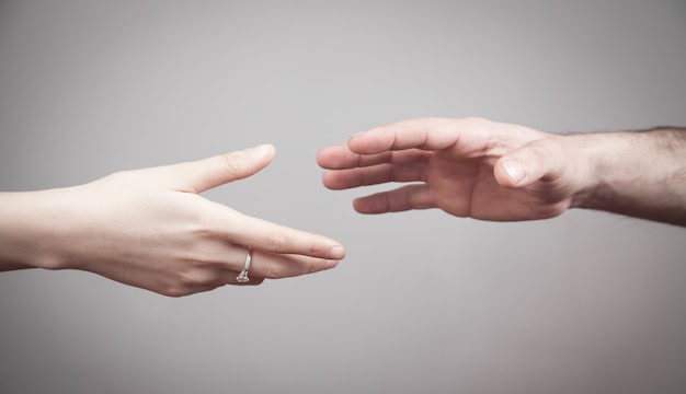 Man and woman hands on grey background.