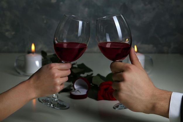 Man and woman hands holding red wine glasses in restaurant