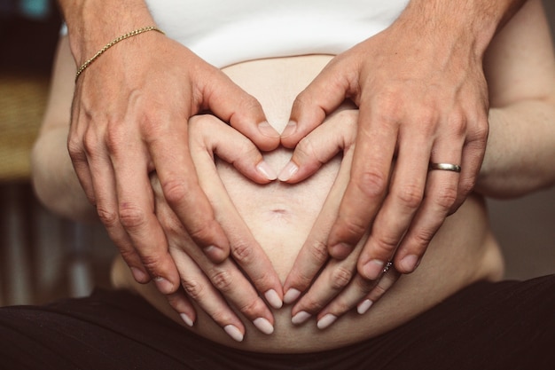 Man and woman hands on the pregnant belly