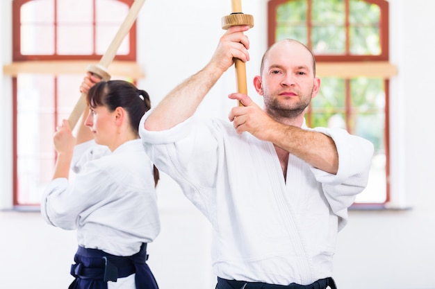 Foto uomo e donna che hanno lotta con la spada di aikido