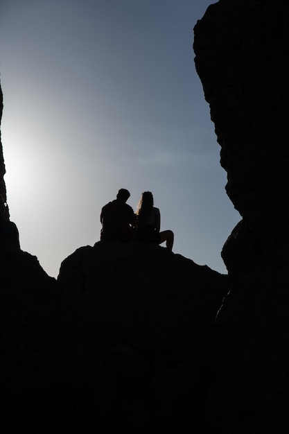 Man and woman hikers looking out to a beautiful sunset Adventure and active lifestyle concept
