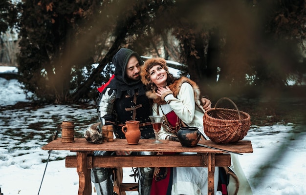 Man and woman in historical costumes at a wooden table